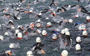 Athletes race into the water for the swimming start of the Ironman triathlon in Klagenfurt